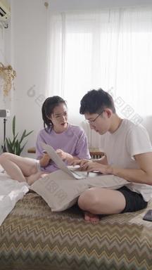 年轻情侣在家使用手机和<strong>电脑</strong>